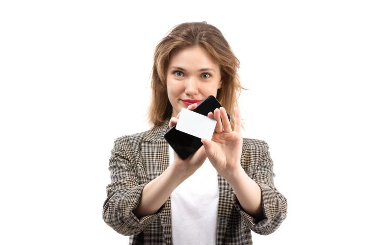 front-view-young-beautiful-lady-white-t-shirt-black-jeans-coat-holding-black-smartphone-white-card-smiling-white